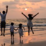 family holiday  Asian young happy family enjoy vacation on beach in evening Dad