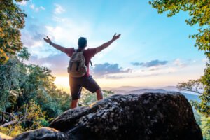 Young trekking man standing on rocky mountain peak salutetravelscom salutetravelscom travel Young trekking man standing on rocky mountain peak Young trekking man standing on rocky mountain peak